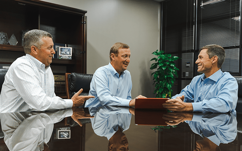 Mobilease owners talking to their BOK financial representative in their office. 